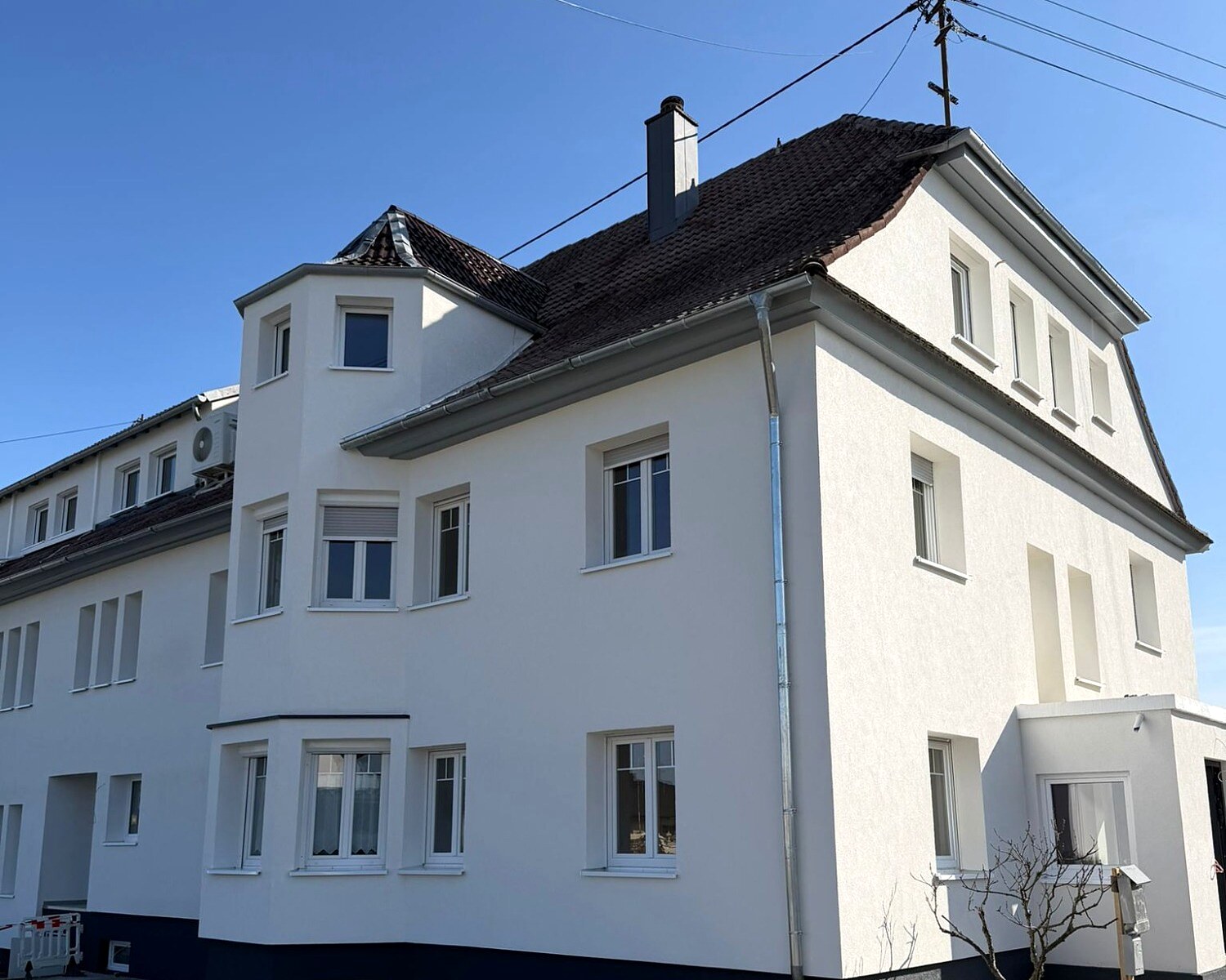 Saniertes weißes Wohnhaus mit Erkerturm in Hugsweier: neue Fenster, neuer Sockel